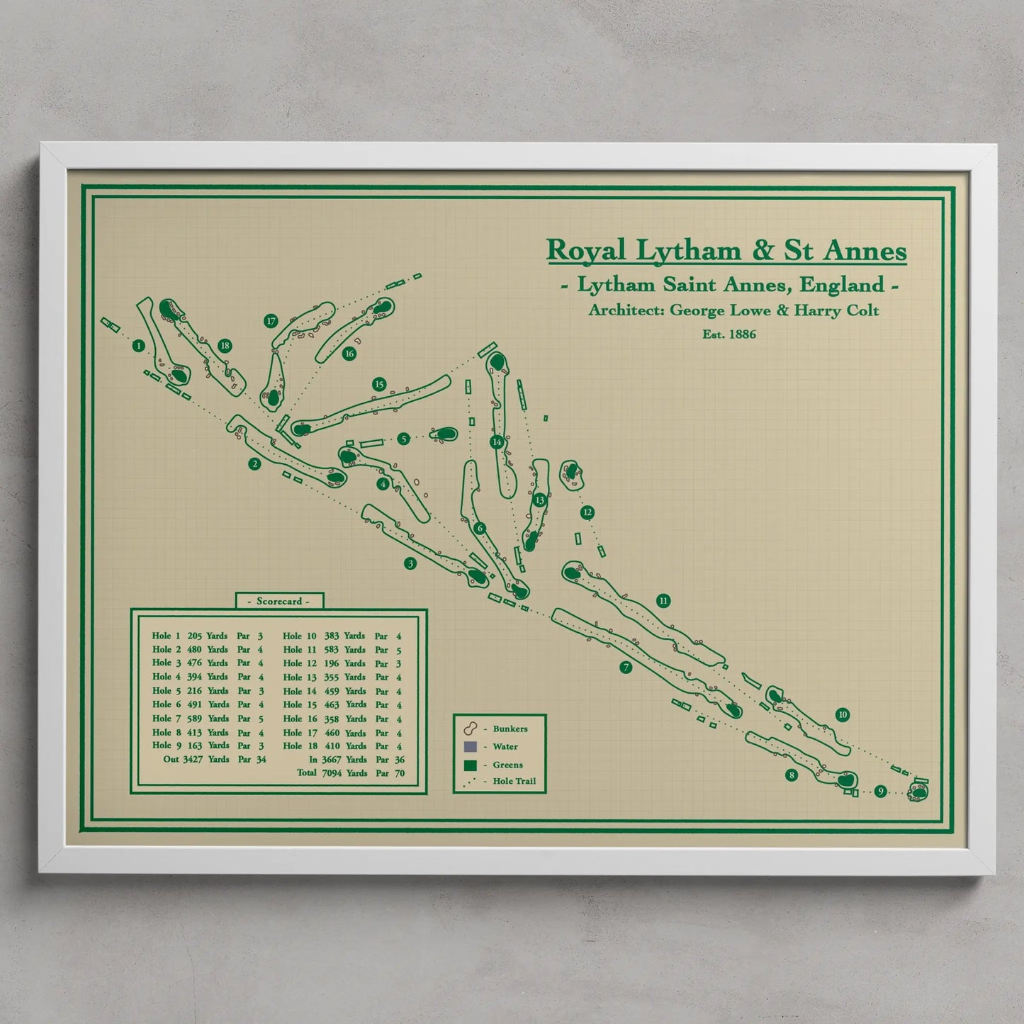 A framed vintage-style golf map print of Royal Lytham & St. Annes, England, featuring green course paths and markers on a warm beige background, enclosed in a white frame against a light gray wall.