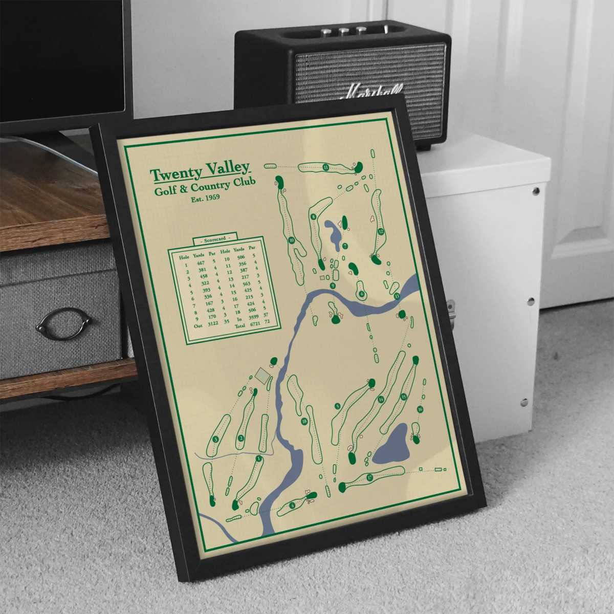 A framed  golf map print leaning on a carpeted floor of Twenty Valley Golf and Country Club