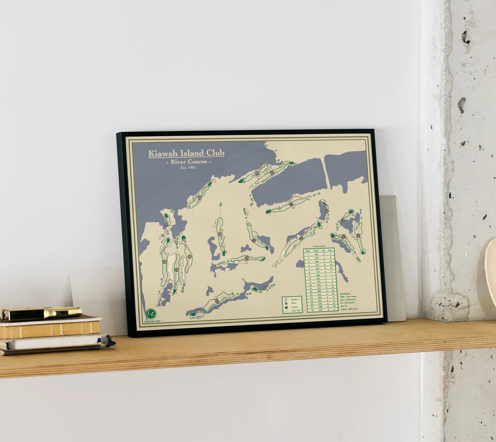 Framed map of Kiawah Island Club on a wooden shelf against a white wall.