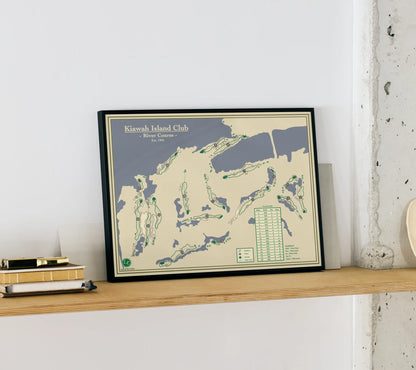 Framed map of Kiawah Island Club on a wooden shelf against a white wall.