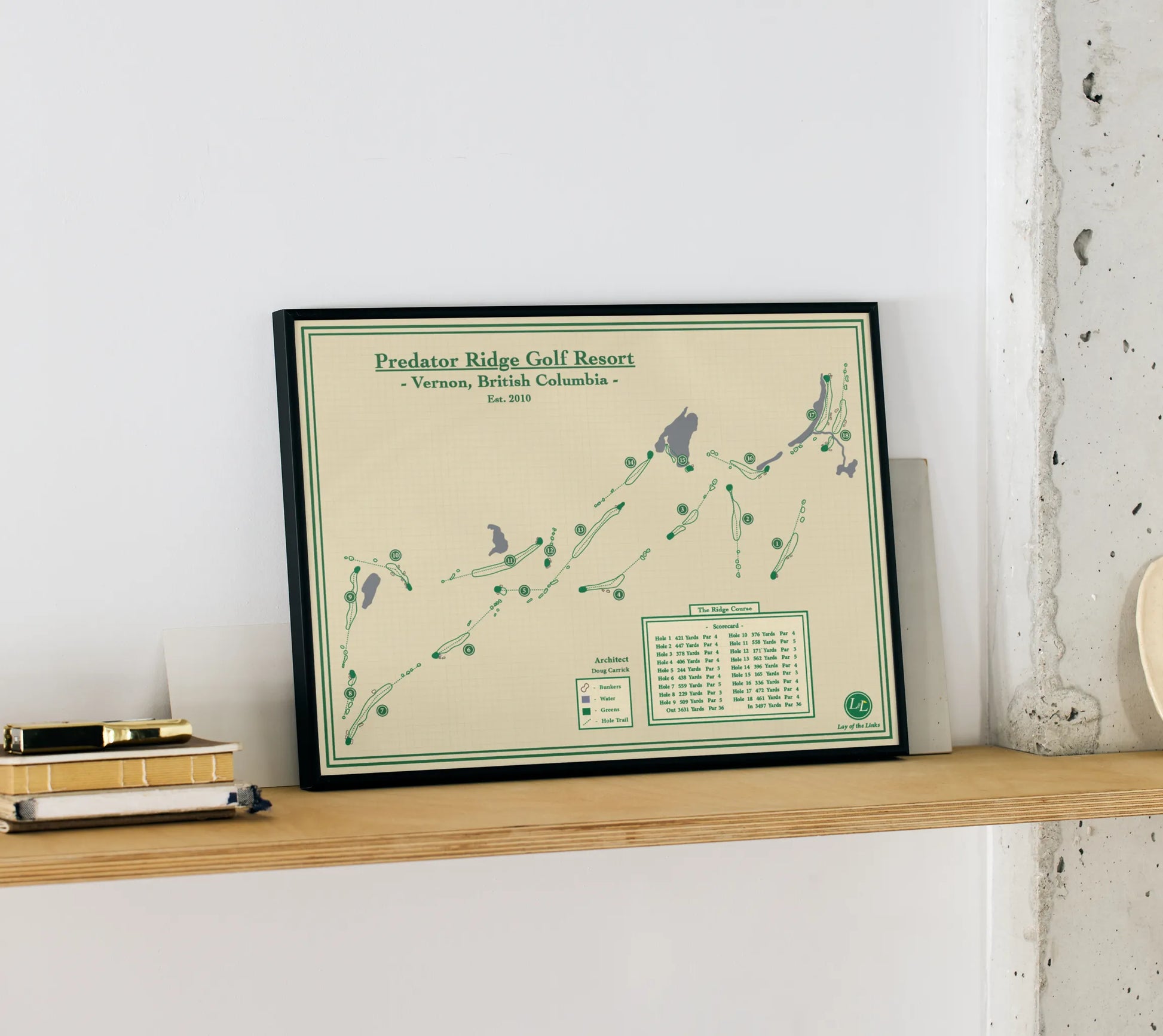 Framed map of Predator Ridge Golf Resort on a wooden shelf against a white wall.