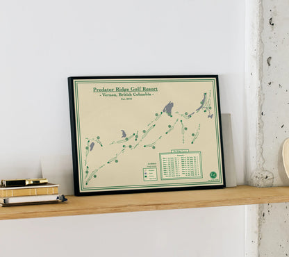 Framed map of Predator Ridge Golf Resort on a wooden shelf against a white wall.