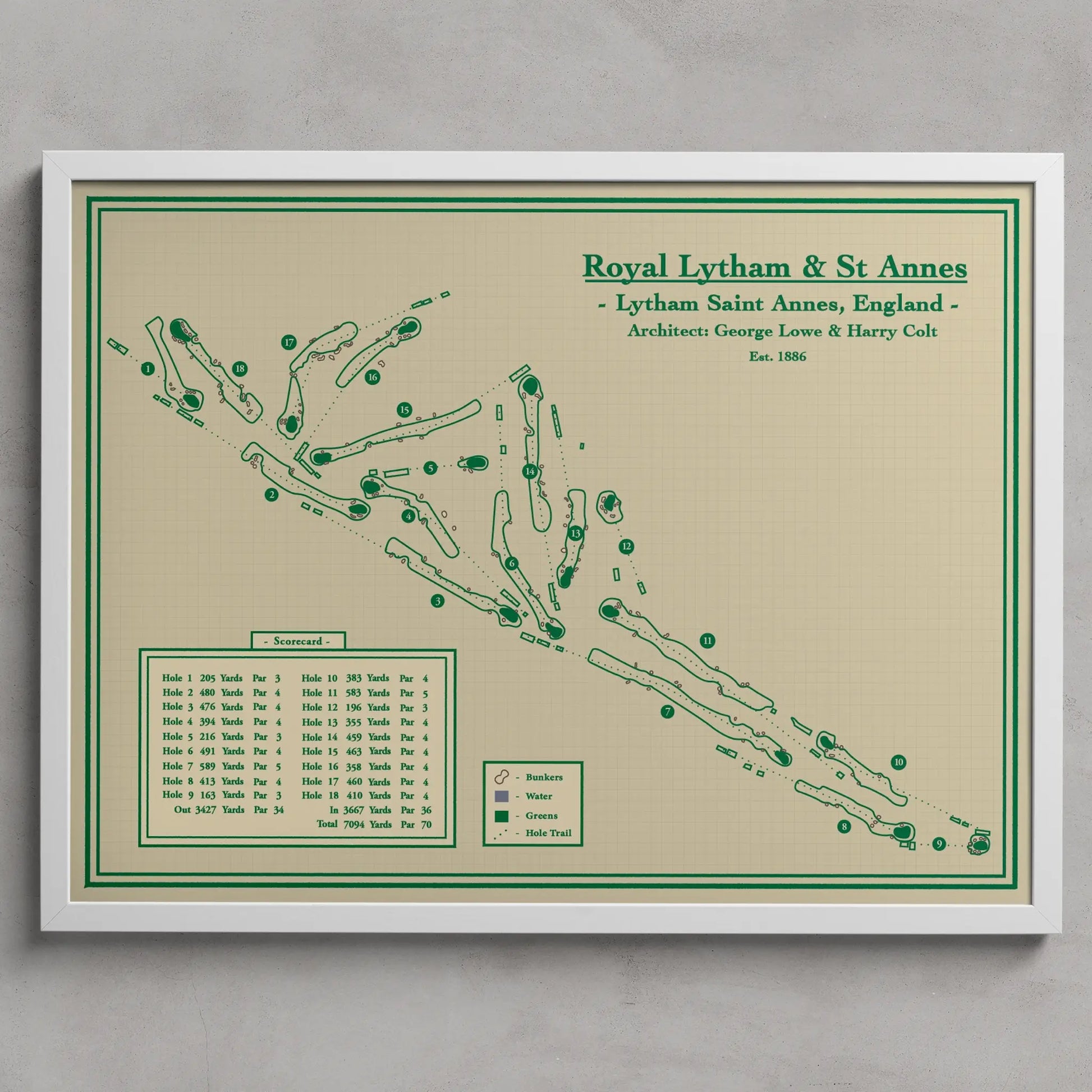 A framed vintage-style golf map print of Royal Lytham & St. Annes, England, featuring green course paths and markers on a warm beige background, enclosed in a white frame against a light gray wall.