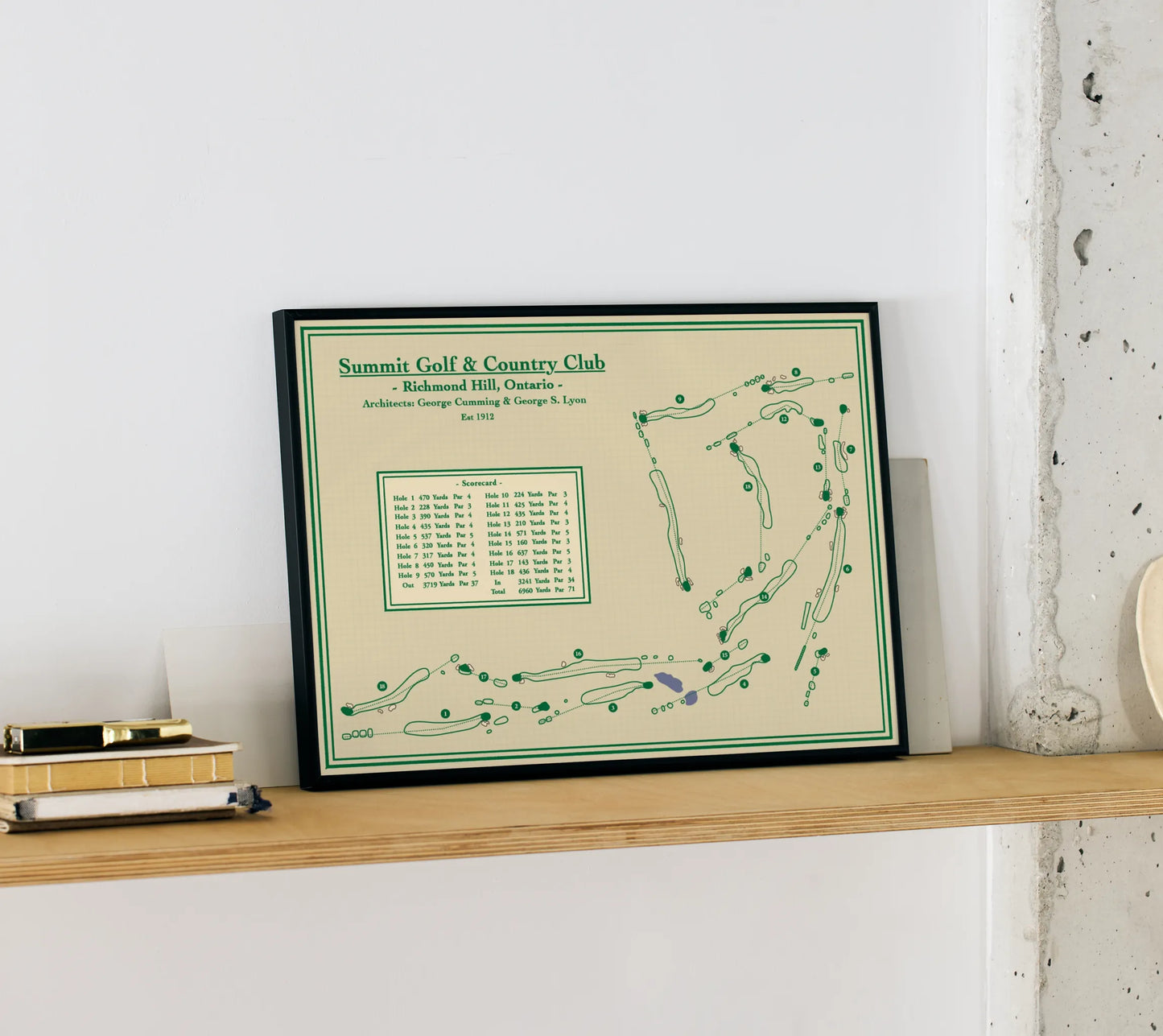 Framed golf course map of Summit Golf & Country Club on a shelf against a white wall.