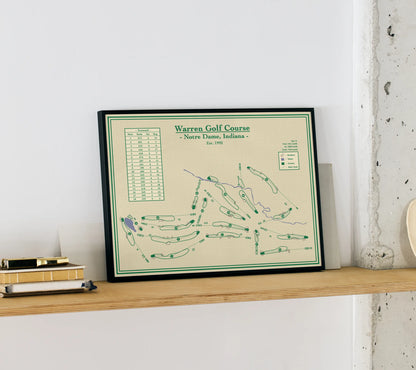 Framed course map of Warren Golf Course on a wooden shelf against a white wall.