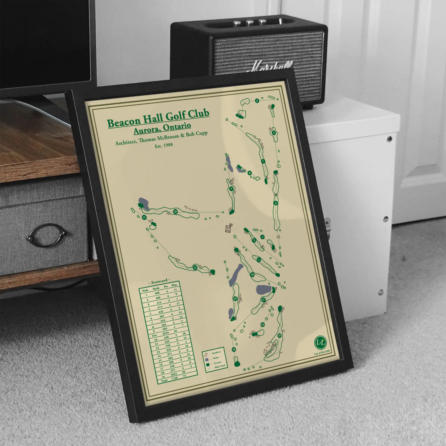 Framed golf course map of Beacon Hall Golf Club on a carpeted floor with a Marshall speaker in the background.